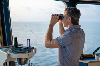 ooking through binoculars. Marine industry. COLREG collision regulations