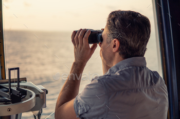 ooking through binoculars. Marine industry. COLREG collision regulations