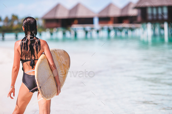 Beautiful surfer woman ready to surfing in turquoise sea, on stand up paddle board at exotic / Photodune, Misc
