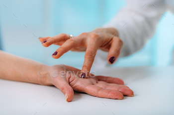 Examining the hand of a senior patient with carpal tunnel syndrome. / Photodune, Misc
