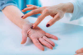 Examining the hand of a senior patient with carpal tunnel syndrome. / Photodune, Misc