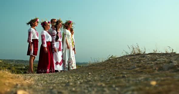 Young Beautiful Women in Slavic Dresses and with a Wreath on Their Heads are Standing on the