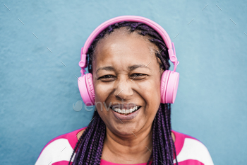 Senior african girl listen playlist music with headphones - Focus on face / Photodune, Misc