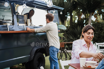 Multiracial people eating at food truck restaurant outdoor - Focus on hispanic woman face / Photodune, Misc