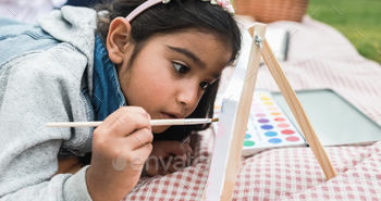 Happy indian little girl having fun painting outdoor at city park - Main focus on girl face / Photodune, Misc