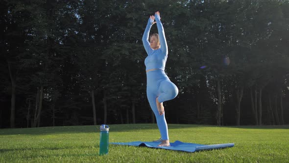 Blonde Woman Practicing Yoga on Sunlit Park Lawn