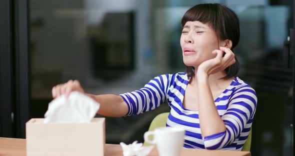 Young woman feeling sick, sneezing and sitting at home