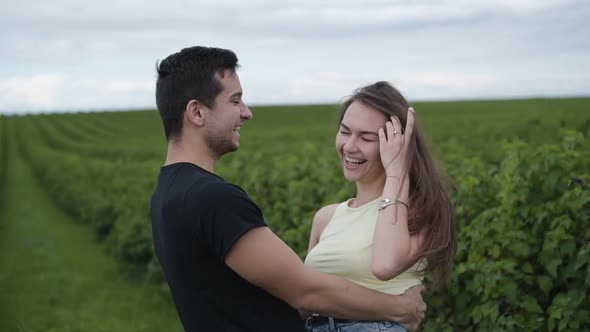 Happy Couple Rejoicing in the Embraces Among Green Plantation