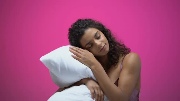 African-American Woman Sleeping on Pillow Isolated on Pink Background, Rest