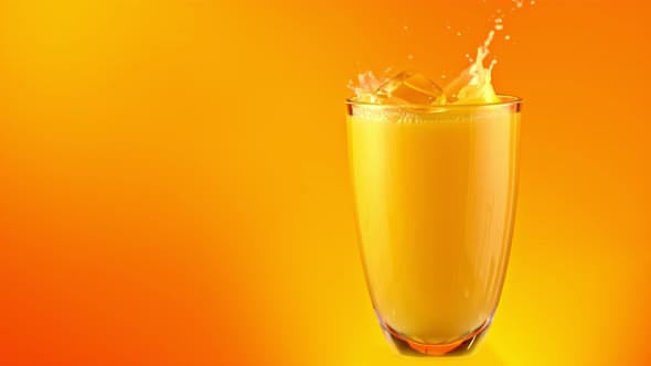 Super Slow Motion Shot of Ice Cubes Falling Into Glass of Orange Juice and Making Splash at 1000Fps