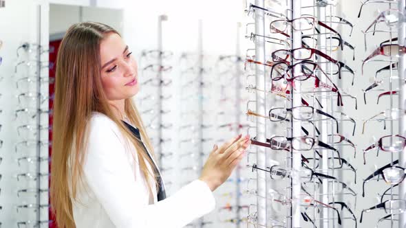 Lovely Woman Choosing Glasses at Optics Store