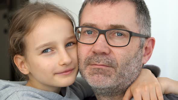 Family Portrait of Senior Father and Little Blond Daughters are Hugging Indoors and Smiling Fathers