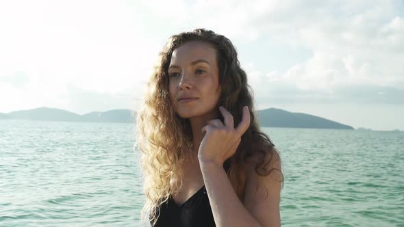 Model Wearing Swimsuit Looking Into Shore From Beach