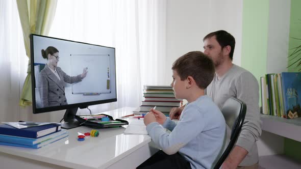 Children Learning Online, Parent Helps His Son Learn Lessons Uses Modern Technology for Distance