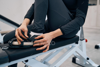 Closeup of young lady wears special rehab shoes on her feet to practice on recreational simulator / Photodune, Misc