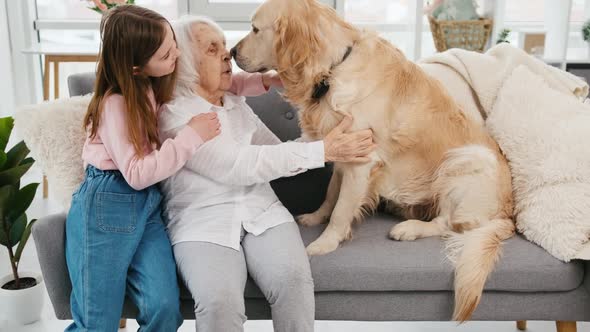Grandmother and Granddaughter with Golden Retriever Dog