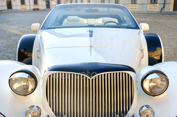 Close-up of the front of a white vintage car in the courtyard of the castle / Photodune, Misc