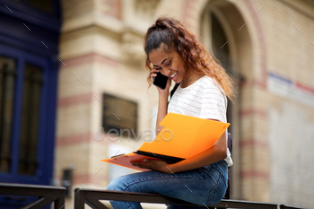 student on phone in front of university / Photodune, Misc
