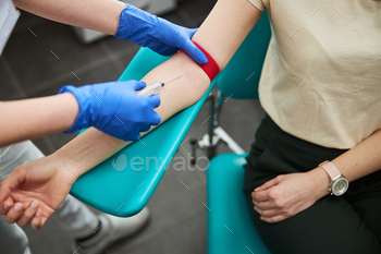 Professional female phlebotomist performing a venipuncture procedure / Photodune, Misc