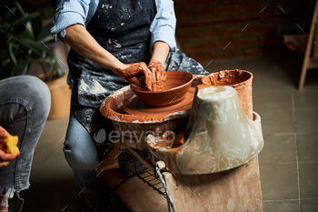 Female potter making clay pot in workshop / Photodune, Misc