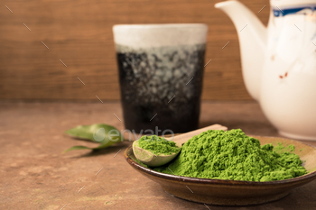 Close up of green tea powder in dish on the table with ceramic cup and teapot background. / Photodune, Misc