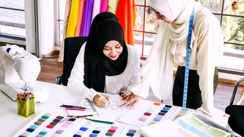 Beautiful muslim women sketching clothes silhouette together at the office. / Photodune, Misc