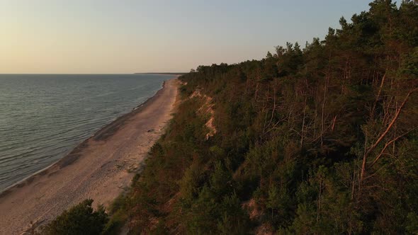 Aerial Forward: Beautiful Sunset at Baltic Sea with Latvian Forest and Sand Precipice