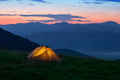 Orange tourist tent illuminated from inside on mountain - PhotoDune Item for Sale