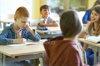 Sad schoolboy writing in note book / Photodune, Misc