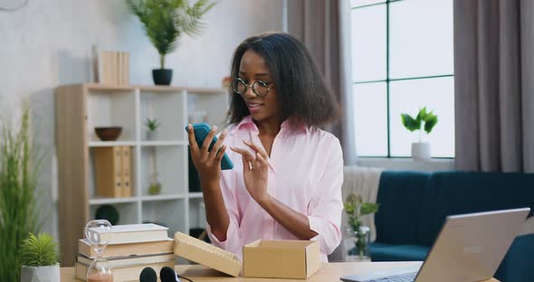 Female Blogger in Glasses Recording Video About New Phone from Gift Box
