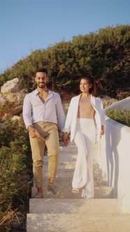 Smiling Ethnic Couple Walking and Kissing on Stairs