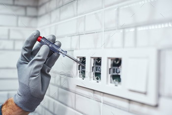 Electrical network measurement. Close-up of senior handyman setting new sockets / Photodune, Misc