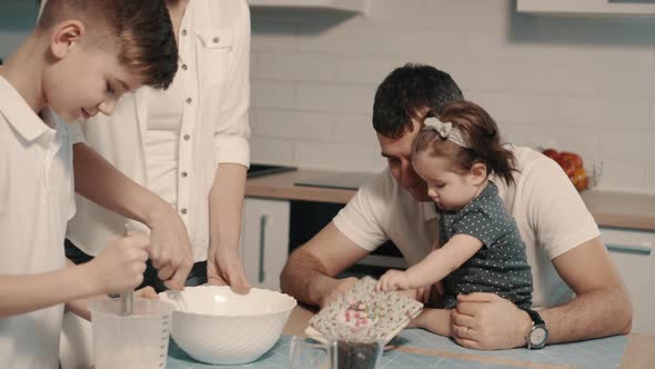 Young Family Preparing Food in Kitchen at Home