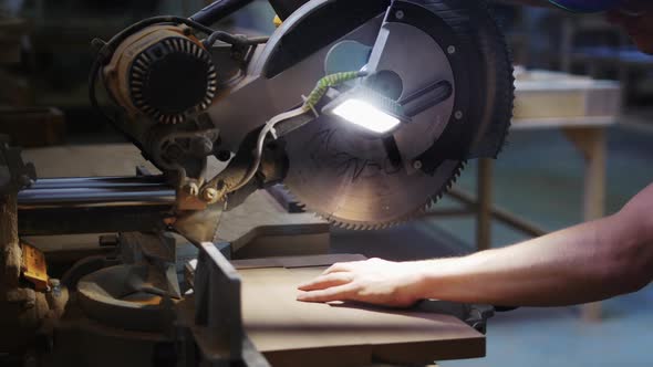 Carpentry Works in Workshop  Man Worker Cutting Notches on the Wooden Desk Using a Big Circular Saw