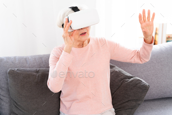 Senior woman playing with VR at home / Photodune, Misc
