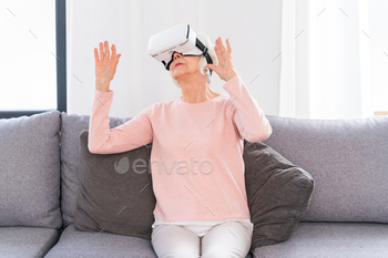 Senior woman playing with VR at home / Photodune, Misc