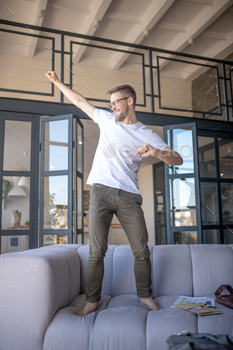 A young man in a white tshirt feeling awesome at home / Photodune, Misc
