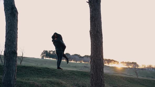 The Young People in Love Dressed in Black Hug Tightly the Man Takes Her in His Arms and Lifts Her