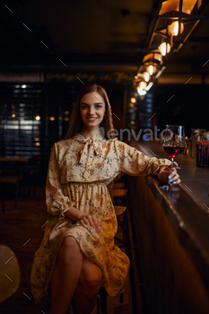 Alone woman with glass of wine sitting in bar / Photodune, Misc