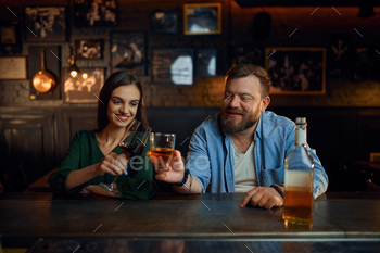 Happy couple drinks alcohol at the counter in bar / Photodune, Misc