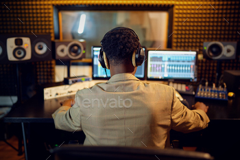 Male sound engineer at mixing consol, back view / Photodune, Misc