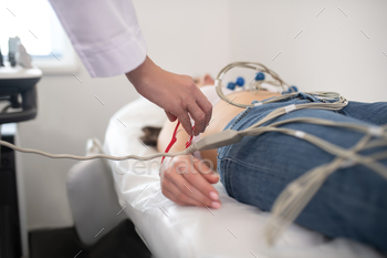 Doctor in white robe making electrocardiogram to the patient / Photodune, Misc