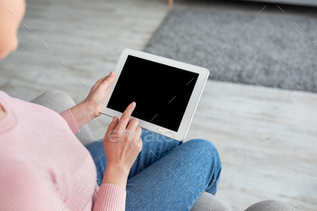 Young lady using tablet computer with empty screen for your website or app advertisement, mockup / Photodune, Misc
