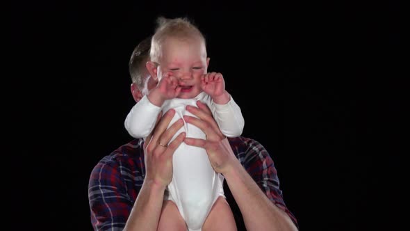 Affectionate Father Playing with Baby Son - Lifting Him Up and Making Him Laugh. Black. Close Up