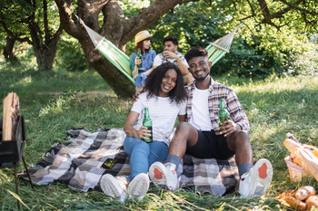 Four diverse friends enjoying picnic time on nature / Photodune, Misc