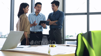 Team of young Asian architects discussing on construction site. / Photodune, Misc