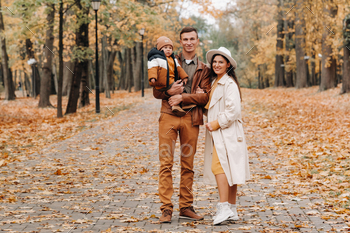Father and mother with son walking in the autumn Park. A family walks in the Golden autumn in a / Photodune, Misc