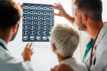 Doctors discussing patient's diagnosis looking at x-rays in a hospital / Photodune, Misc