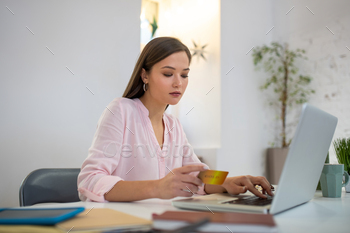 Serious young woman doing the online shopping / Photodune, Misc