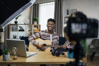 Inspired afro man playing guitar and recording video / Photodune, Misc